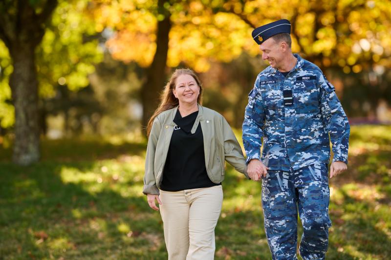RAAF member walking along while holding his wife's hand